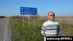 Правозащитник Абдурешит Джеппаров у таблички на въезде в село Серебрянка
