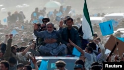 Abdullah Abdullah (in gray) sits atop a vehicle at an election rally in the Panjshir Province on March 31, 2014.