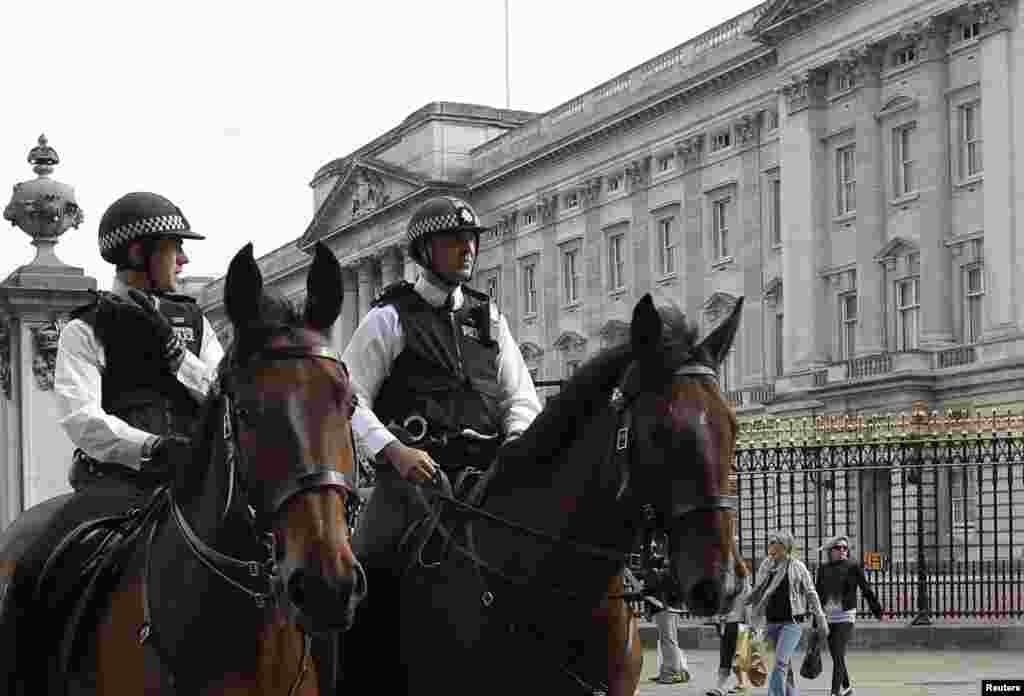 Mounted police officers patrol outside Buckingham Palace in London.