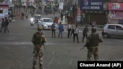 Indian paramilitary soldiers stand guard during curfew-like restrictions in Jammu on August 5.