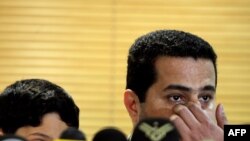 Iranian nuclear scientist Shahram Amiri, with his son, addresses journalists on his arrival at Imam Khomeini Airport in Tehran on July 15.