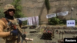 A Pakistani soldier stands by ammunition seized during a military operation against militants, in the of town of Miran Shah, North Waziristan on July 9, 2014.