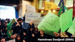 Students holding hand-written signs in green – the color of the opposition movement-- against Hossein Shariatmadari, editor of the ultra-hard-line daily "Kayhan," including one that read: "The university is not a place for a lier". 2014