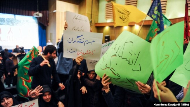 Students holding hand-written signs in green – the color of the opposition movement-- against Hossein Shariatmadari, editor of the ultra-hard-line daily "Kayhan," including one that read: "The university is not a place for a lier". 2014