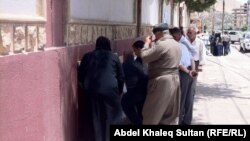 Voters check candidate lists in Duhok, Iraq, on June 20 during elections that were postponed in two provinces.