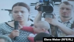 Камилла Пиралиева, одна из подсудимых по делу Серика Ахметова, с ребенком на руках. Караганда, 28 июля 2015 года.