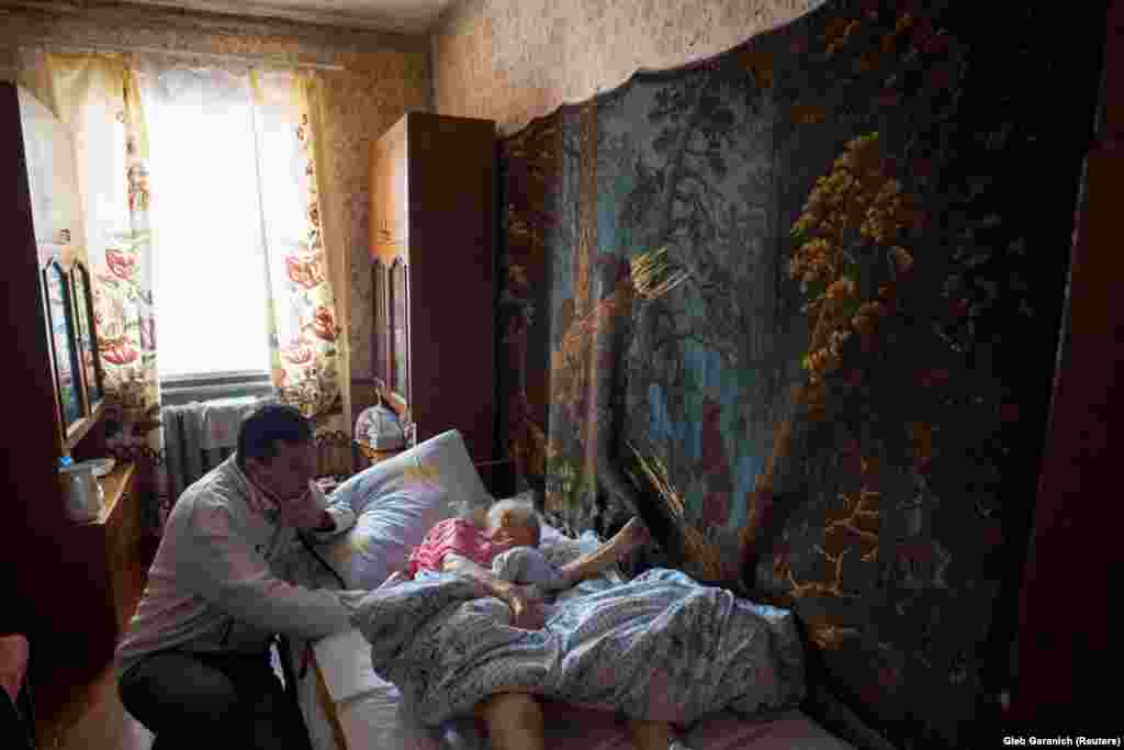 Examining a patient at her home in the village of Ivankovichy. Rozumiy's patients are mostly very old or very young, with working-age adults seemingly avoiding the costs of medicines wherever possible.