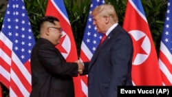 АҚШ президенті Дональд Трамп (оң жақта) пен Солтүстік Корея басшысы Ким Чен Ынның алғашқы кездесуі. Сингапур, 12 маусым 2018 жыл.