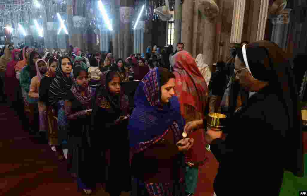 Pakistani Christians take communion during a Christmas Mass at St. Anthony's Church in Lahore on December 25. Pakistan is overwhelmingly Muslim and, with around 2 percent of the population, Christians are among the country's most marginalized citizens. (AFP/Arif Ali)