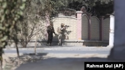 Afghan security personnel take a position near the Shamshad TV station on November 7.