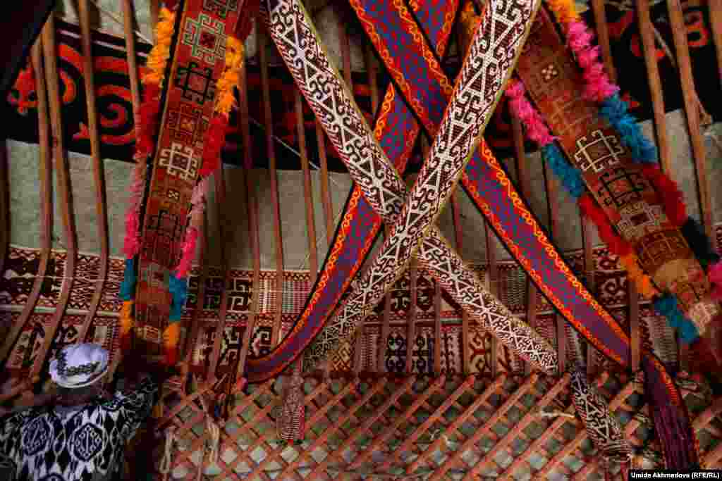 Astara hangs woven fabric to decorate the interior. Past generations used to carry yurts with them to mountain pastures where they would spend the summer tending to herds of livestock.