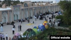 Thousands of dervishes have gathered at the shrine of Beydokht to protest a court summons for their leader.