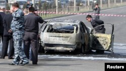 Federal howpsuzlyk gullugynyň (FSB) işgärleri Dagystanyň Mahaçkala oblastynda bomba bilen partladylan maşynyň ýanynda, 2012-nji ýylyň 16-njy apreli.