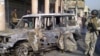 A soldier stands guard near a burnt vehicle after a bomb attack in Alawi district in central Baghdad on December 22.