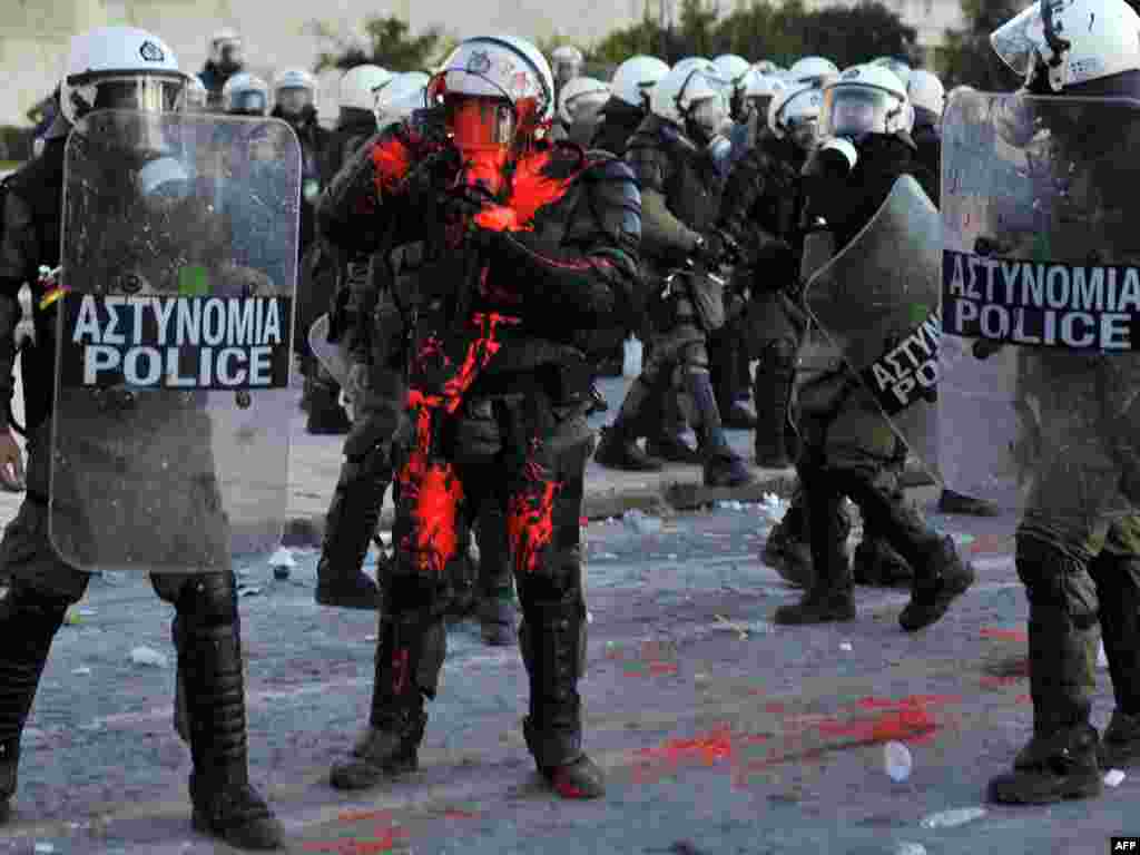A policeman is hit with red paint while police try to disperse protesters from central Athens' Syntagma Square. (Louisa Gouliamaki for AFP)