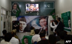 Activists of the All Pakistan Muslim League watch in Karachi as Musharraf speaks to reporters about his return from self-imposed exile on March 1.