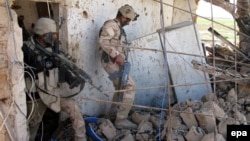 Иракские солдаты проверяют место сражений с боевиками группировки "Исламское государство" (ИГ) на востоке города Тикрит. 15 марта 2015 года. 