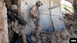 جنديان عراقيان يتفحصان موقع لمسلحي "داعش" داخل مدينة تكريت