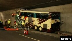 Switzerland -- Emergency services work on the wreckage of a bus that crashed into a motorway tunnel in Sierre, 14Mar2012