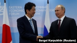 Japanese Prime Minister Shinzo Abe (left) and Russian President Vladimir Putin shake hands during a meeting at the Eastern Economic Forum in Vladivostok, Russia, on September 7.