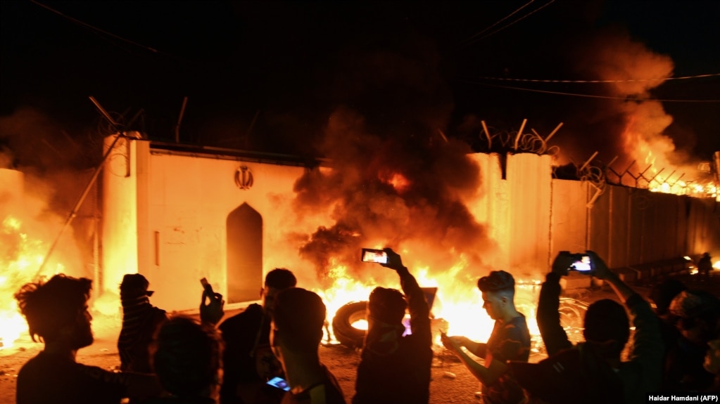 Demonstrators gather as flames start consuming Iran's consulate in the southern Iraqi city of Najaf on November 27. 