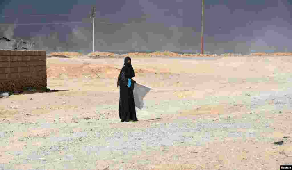 A displaced woman, who fled Islamic State violence, walks on the outskirts of Al Qayyarah, Iraq. (Reuters)