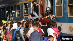 Мигранты у поезда в терминале будапештского железнодорожного вокзала Келети, 3 сентября 2015 года.