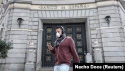  man wears a protective face mask as he walks past Banco de Espana (Bank of Spain), amidst concerns over coronavirus outbreak, in Barcelona, Spain March 14, 2020. 