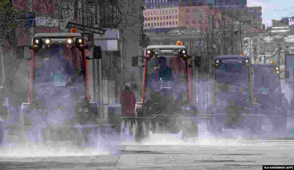 Municipal vehicles spray disinfectant on the deserted streets of central Moscow on April 12 during a strict lockdown in Russia to stop the spread of the coronavirus. (AFP/Yury Kadobnov)