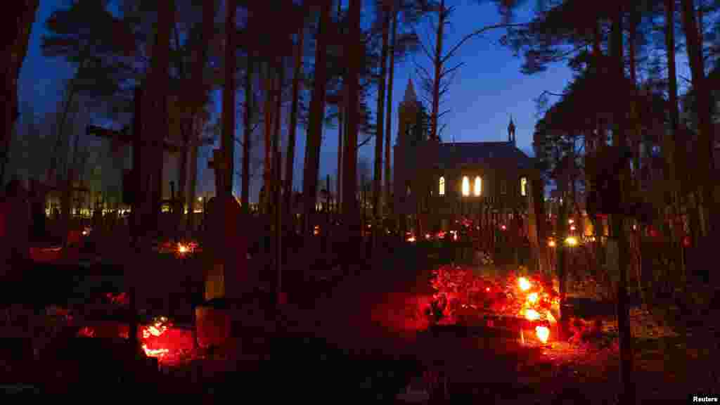 Candles placed at graves are seen at a cemetery in the Belarusian village of Ivenets, some 50 kilometers southwest of Minsk. Catholics in Belarus mark All Saints Day by visiting the graves of their relatives and friends.(Reuters/Vasily Fedosenko)