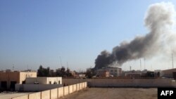 Smoke billows after a government building during fighting between Iraqi forces and IS militants in Ramadi on March 11. 