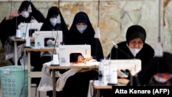 Иранские женщины из полувоенных отрядов "басиджи" шьют защитные маски