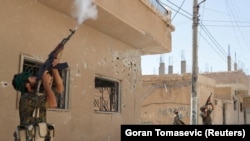 Kurdish fighters fire rifles at a drone operated by the Islamic State militants in Raqqa, Syria, in 2017.