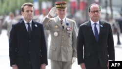 Current French President Francois Hollande (second-right) and President-elect Emmanuel Macron (left) take part in a ceremony to mark the end of World War II, in Paris on May 8.