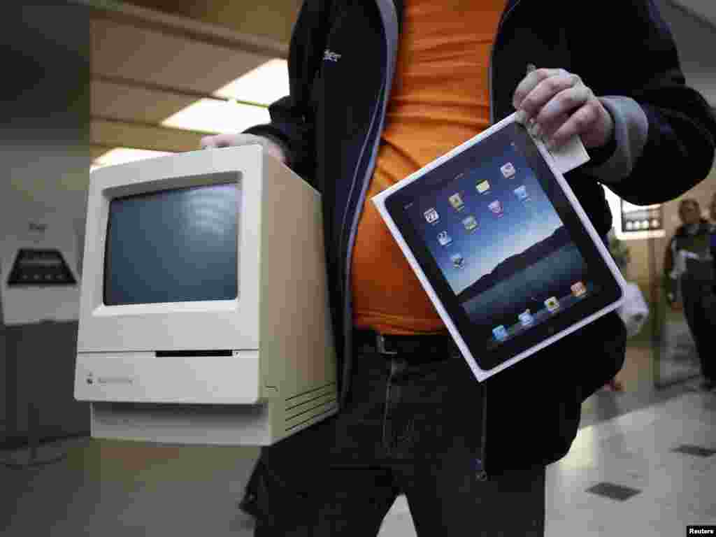 A man shows off his Apple Macintosh Classic computer from 1990 along with his newly purchased Apple iPad at an Apple store in Hamburg, Germany in 2010.