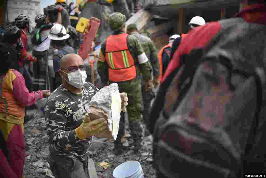 MEXICO -- Volunteers remove rubble during the search for survivors in a flattened building in Mexico City on September 20, 2017