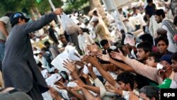 Anti-government protesters receive free food as they continue their sit-in protest for the sixth day in Islamabad, August 20, 2014.