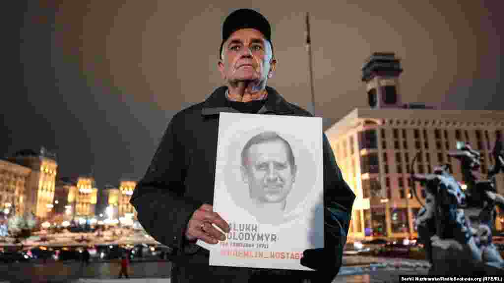 Участник акции держит портрет заключенного в Крыму Владимира Балуха