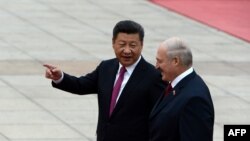 Председатель КНР Си Цзиньпин (слева) беседует с президентом Беларуси Александром Лукашенко, когда они осматривают китайский почетный караул во время церемонии встречи в Доме народных представителей в Пекине, 29 сентября 2016 года
