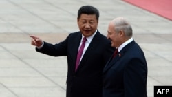 Председатель КНР Си Цзиньпин (слева) беседует с президентом Беларуси Александром Лукашенко, когда они осматривают китайский почетный караул во время церемонии встречи в Доме народных представителей в Пекине, 29 сентября 2016 года