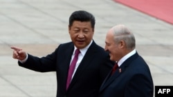 Голова КНР Сі Цзіньпін (ліворуч) розмовляє з тодішнім президентом Білорусі Олександром Лукашенком, коли вони оглядають китайську почесну варту під час церемонії зустрічі в Будинку народних представників у Пекіні, 29 вересня 2016 року