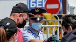 Граждане и сотрудник полиции на одном из контрольно-пропускных пунктов, действовавших на въездах в Алматы весной. 13 мая 2020 года.