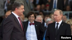 Ukrainian President-elect Petro Proshenko (left) walks past Russian President Vladimir Putin (right) during the commemoration ceremony for the 70th anniversary of D-Day at Sword beach in Ouistreham, France on June 6, before Poroshenko had been sworn in as president.