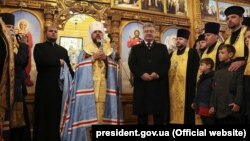 Ukrainian President Petro Poroshenko (center-right) and Metropolitan Epifaniy (center-left), newly elected head of the Orthodox Church of Ukraine, in Dnipro on December 17