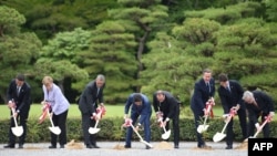 G7 leaders take part in a tree-planting ceremony on the grounds at Ise-Jingu Shrine in the city of Ise on May 26. (Left to right: Italian Prime Minister Matteo Renzi, German Chancellor Angela Merkel, U.S. President Barack Obama, Japanese Prime Minister Shinzo Abe, French President Francois Hollande, U.K. Prime Minister David Cameron, Canadian Prime Minister Justin Trudeau, and European Commission President Jean-Claude Juncker)