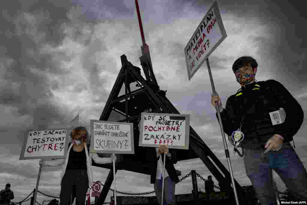 Czech protestors hold placards during a demonstration against the response of the government to the coronavirus pandemic in Prague. (AFP/Michal Cizek)