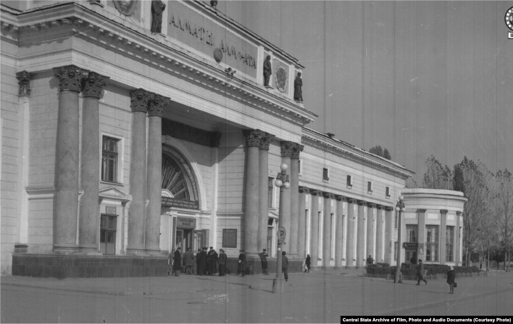 Алматы қаласы теміржол вокзалының ғимараты. 1950 жыл (сол жақта). Верныйда (1921 жылға дейін қала осылай аталды) бұл ауданда зират болған. Құрылыс жүріп жатқан кезде зиратты тасқын шайып кетті. Ғимарат 1936-1939 жылдары салынды. Архитекторлары – Галкин мен Кудрявцев. 1977 жылы реконструкция жасалды. 2012 жылы толық жөндеуден өтті. Вокзалға келіп тірелетін көше атауы бірнеше рет өзгерді. Верный кезінде Старокладбищенская, 1933 жылы Сталин даңғылы, 1961 жылы Коммунистік даңғылы болды. Қазір Абылайхан даңғылы деп аталады.