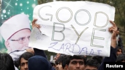 A supporter of Muhammad Tahir-ul-Qadri holds up an antigovernment sign during a fourth day of protests in Islamabad on January 17.