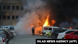Firemen extinguish burning cars after an explosion on November 24 in Adana.