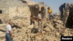 People walk through the rubble of a Shi'ite mosque after it was destroyed in a bomb attack by militants of the Islamic State in the city of Mosul on July 23.